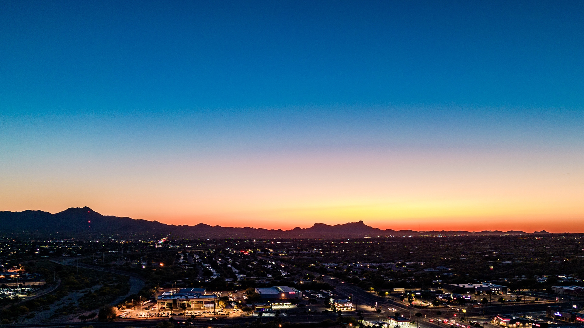Aerial view of the city and mountains at sunset